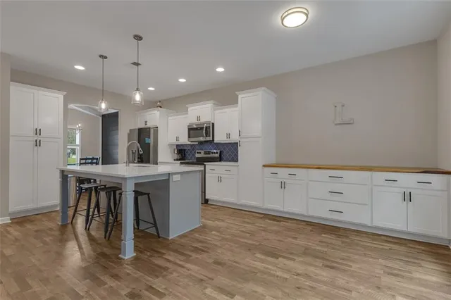 a kitchen with white cabinets and stainless steel appliances