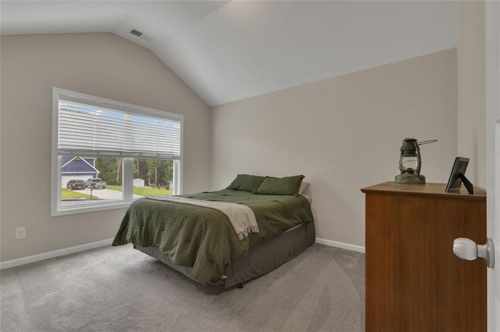 313 Lucy Lane Carrollton, GA 30117 - Photo 23 of 46 a bed sitting in a bedroom next to a window