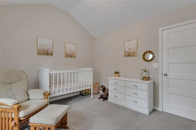 a bedroom with a baby bed a couch and a dresser