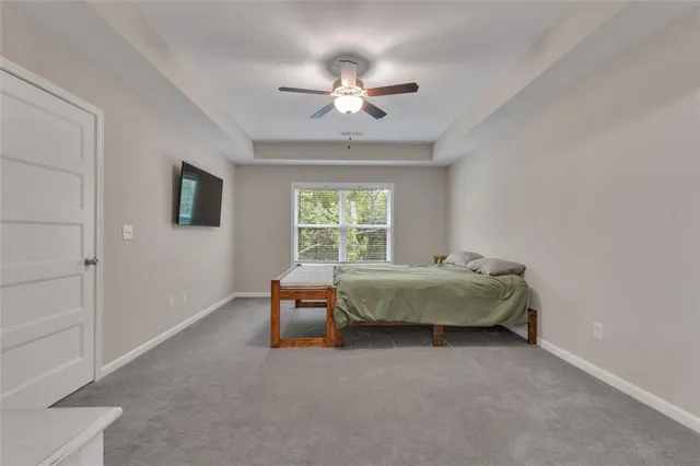 a bedroom with a bed a chandelier and a window