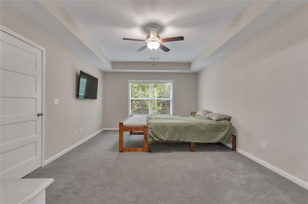 313 Lucy Lane Carrollton, GA 30117 - Photo 34 of 46 a bedroom with a bed a chandelier and a window