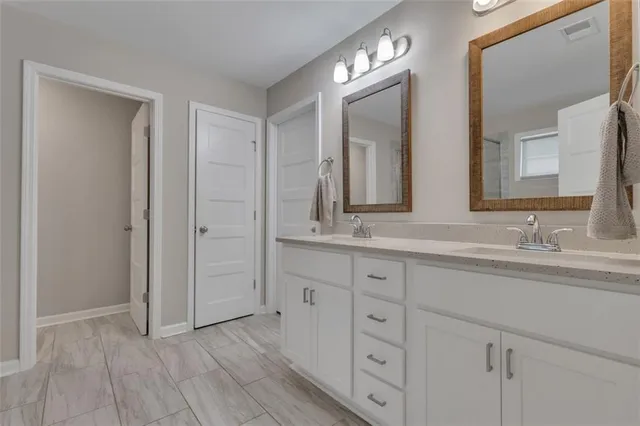 a bathroom with double sink and a mirror