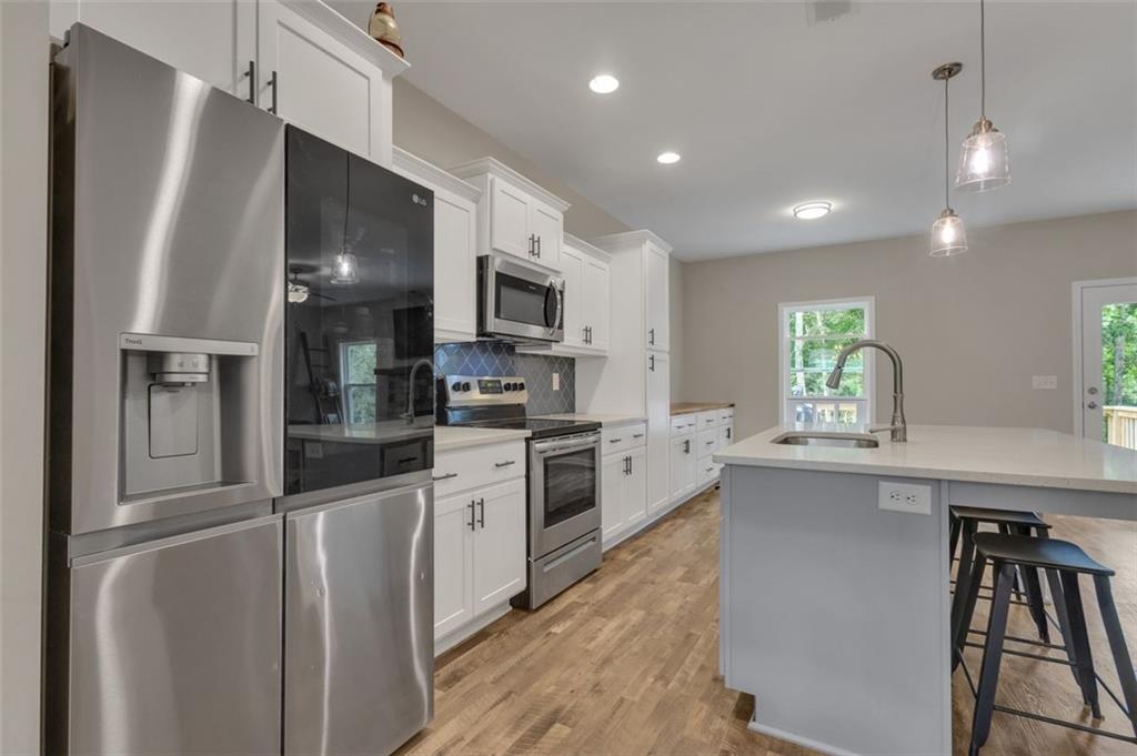 313 Lucy Lane Carrollton, GA 30117 - Photo 6 of 46 a kitchen with kitchen island granite countertop appliances cabinets and a sink