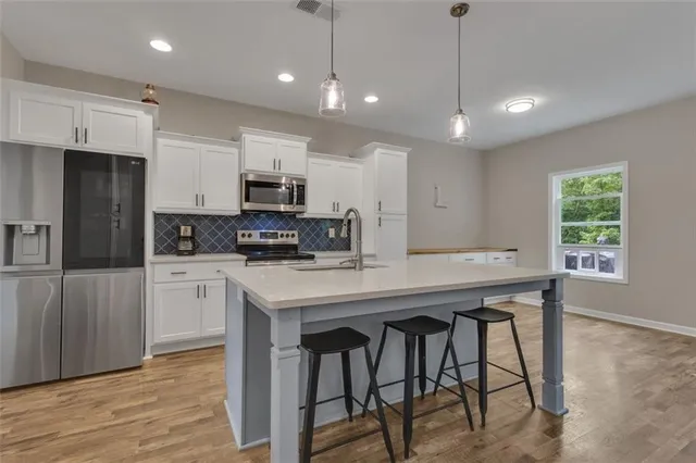 a kitchen with kitchen island microwave and cabinets