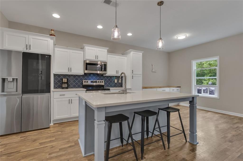 313 Lucy Lane Carrollton, GA 30117 - Photo 7 of 46 a kitchen with kitchen island microwave and cabinets