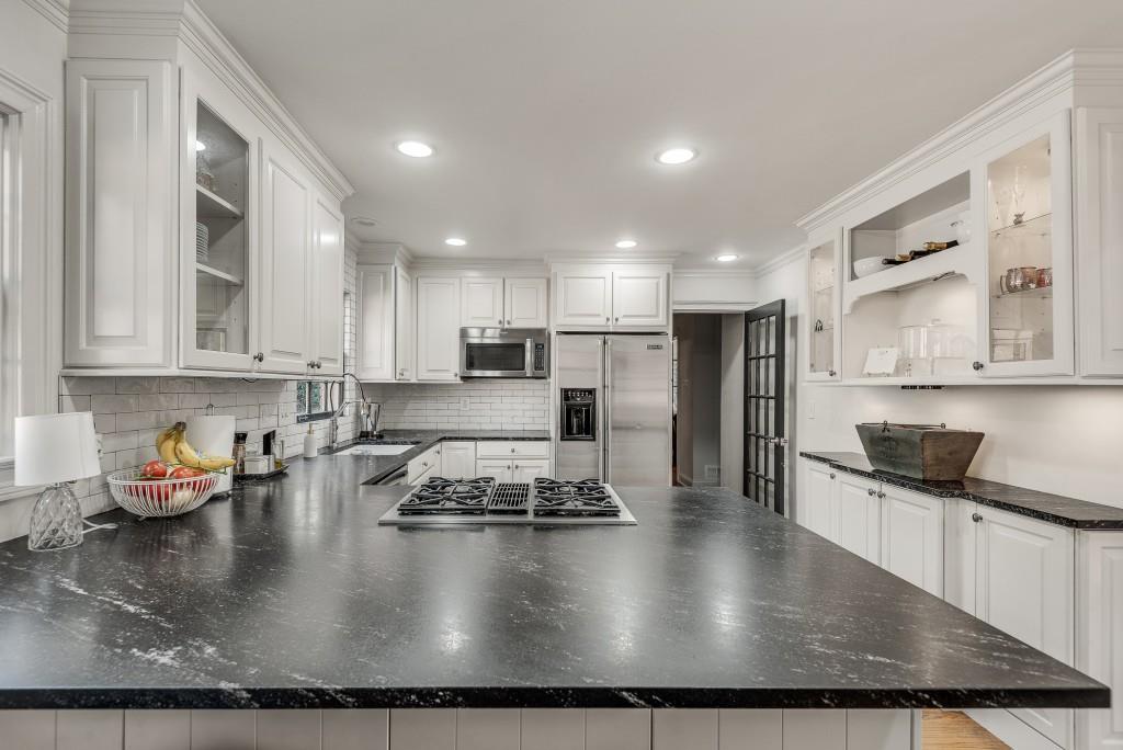 1846 Angelique Drive Decatur, GA 30033 - Photo 15 of 45 a kitchen with kitchen island granite countertop a stove a sink a refrigerator and white cabinets with wooden floor