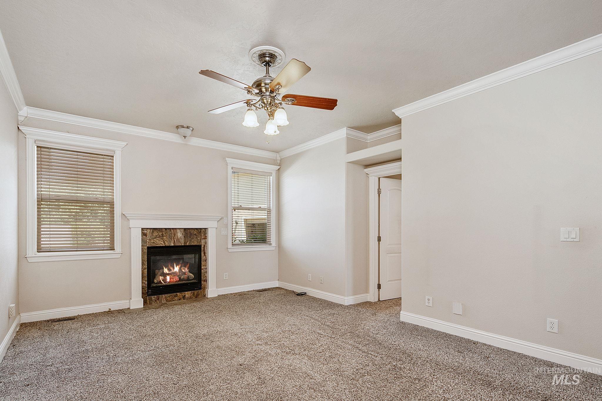 6850 Purple Sage Road Star, ID 83669 - Photo 48 of 50 Room featuring two windows, a ceiling fan with light fixture, and dark gray carpet