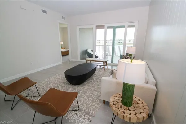 a living room with furniture and a floor to ceiling window
