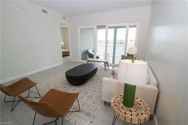 a living room with furniture and a floor to ceiling window