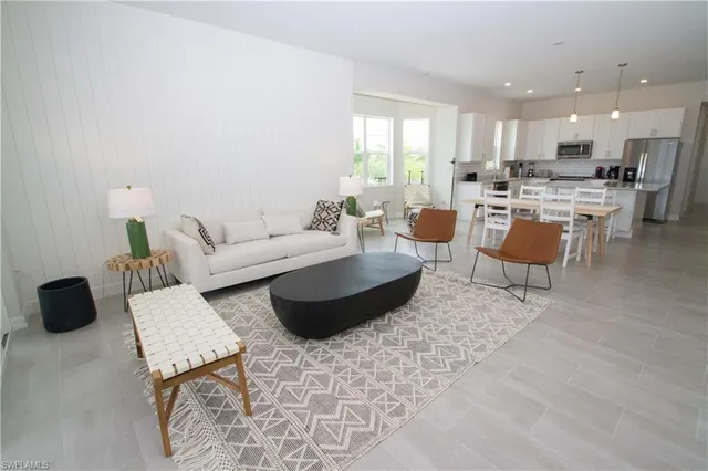 a living room with furniture and a view of kitchen