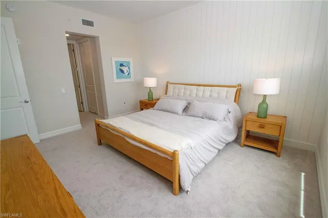 a spacious bedroom with a bed and a lamp