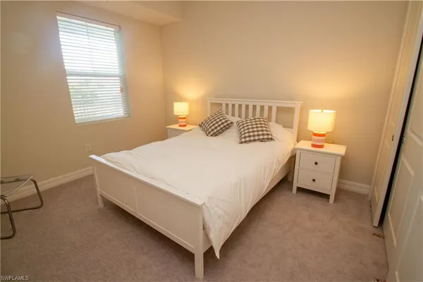 a large bed sitting in a bedroom next to a window