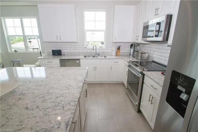 a kitchen with stainless steel appliances granite countertop a stove a sink and a microwave