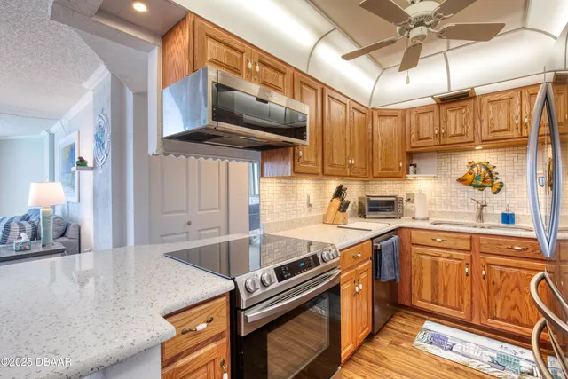 a kitchen with stainless steel appliances granite countertop a sink a stove and a refrigerator