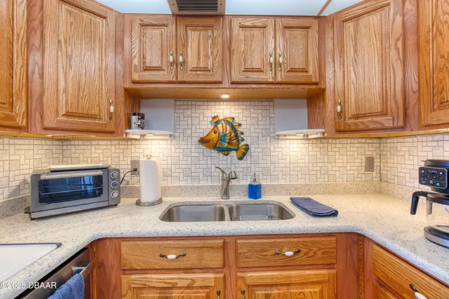 a kitchen with stainless steel appliances granite countertop a refrigerator a stove and a sink with wooden floor