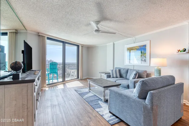 a kitchen with stainless steel appliances granite countertop a refrigerator a sink dishwasher a dining table and chairs with wooden floor