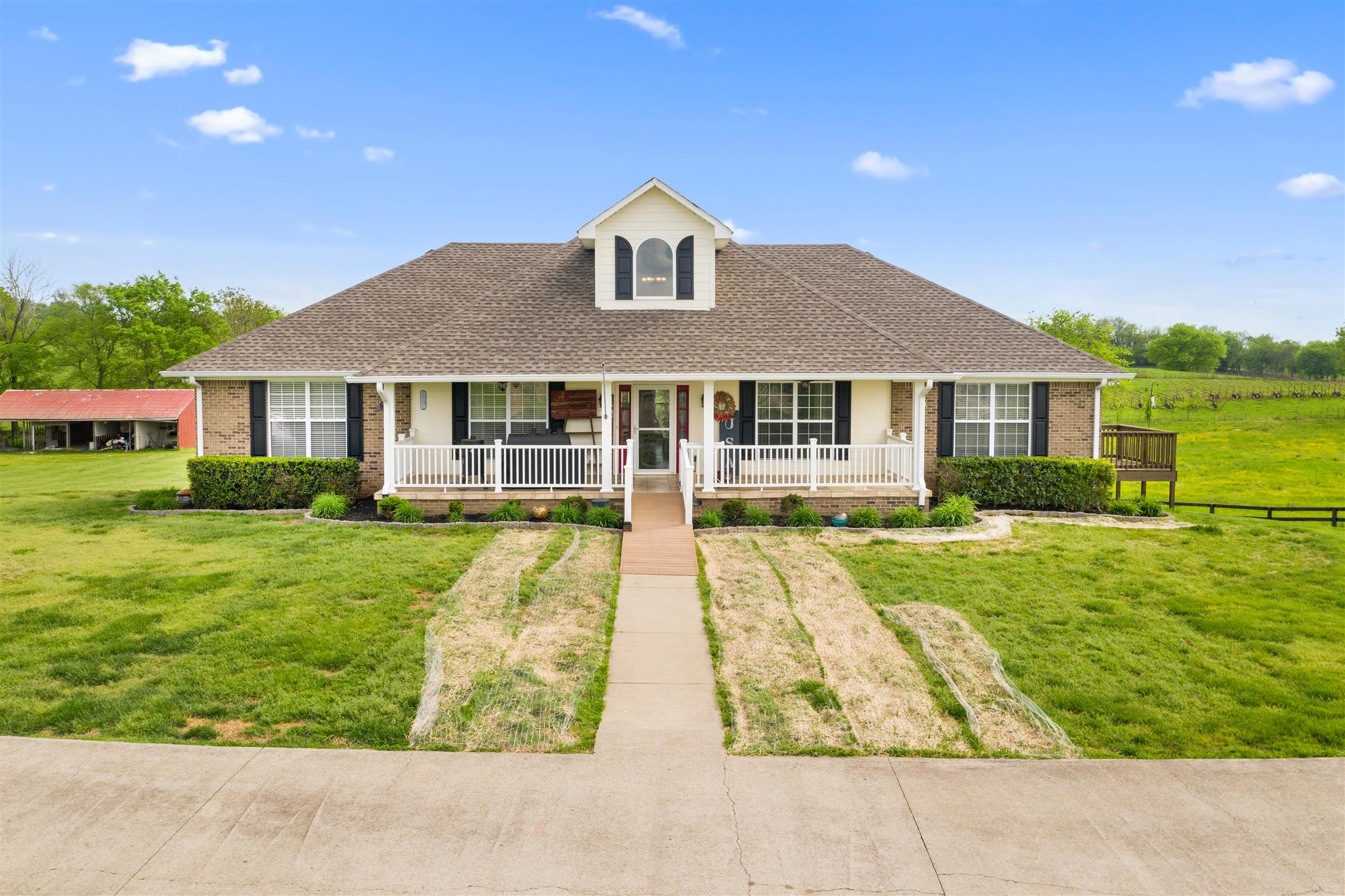 6977 Woodruff Tolleson Road Adams, TN 37010 - Photo 1 of 27 a front view of a house with a yard table and chairs