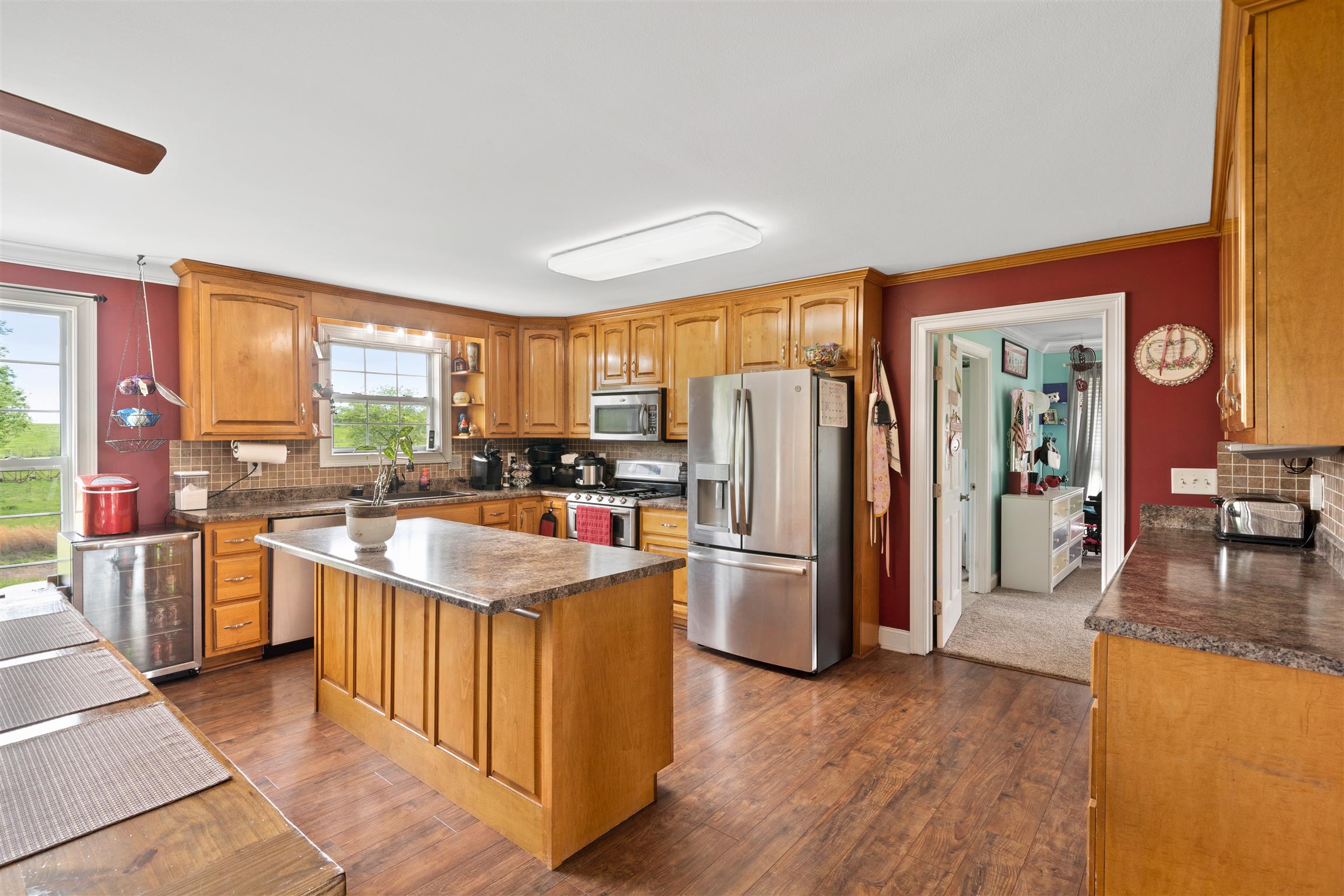 6977 Woodruff Tolleson Road Adams, TN 37010 - Photo 8 of 27 a kitchen with stainless steel appliances granite countertop a refrigerator a sink dishwasher a stove and a dining table with wooden floor