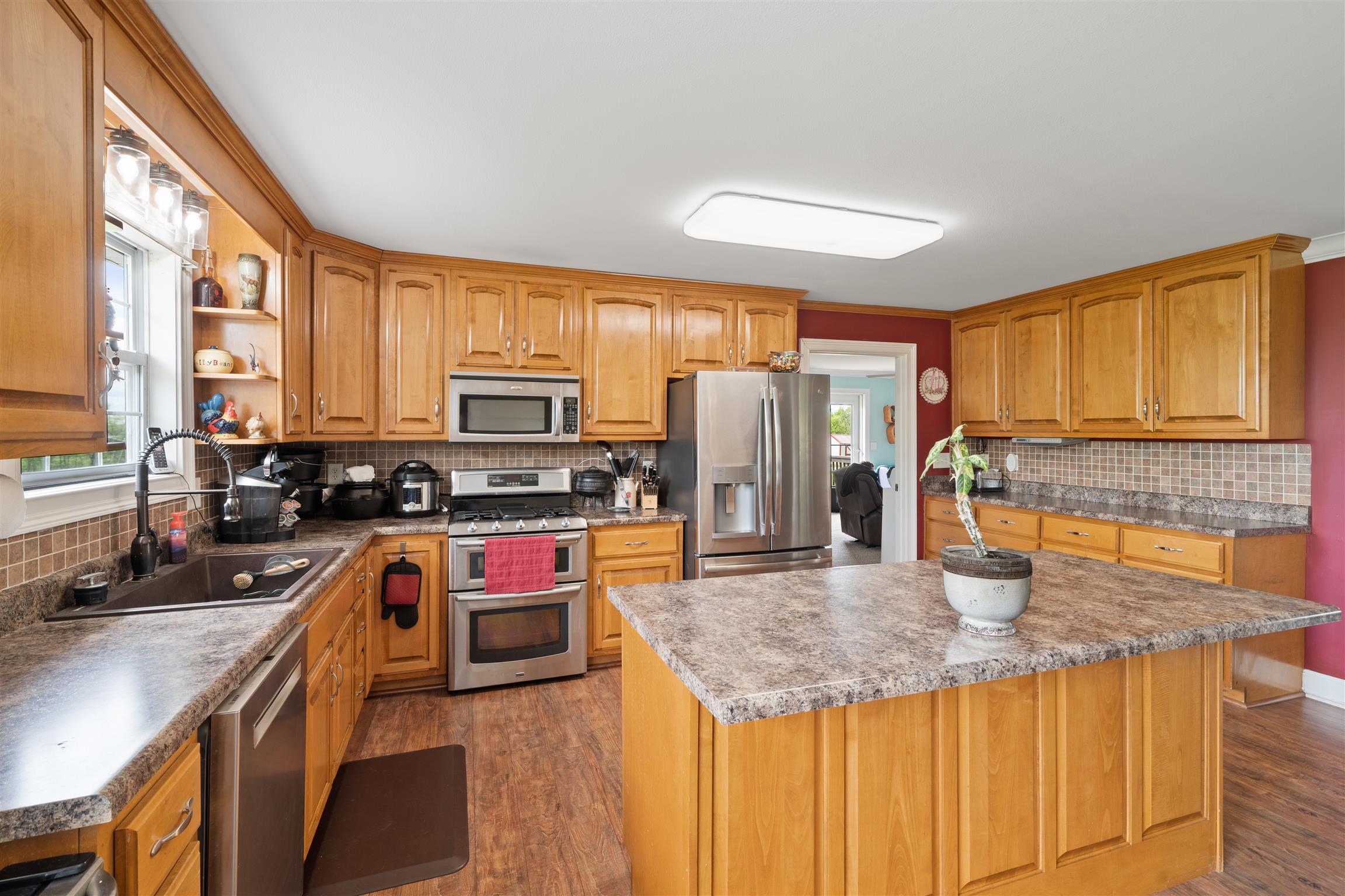 6977 Woodruff Tolleson Road Adams, TN 37010 - Photo 9 of 27 a kitchen with stainless steel appliances granite countertop a sink a stove and a refrigerator