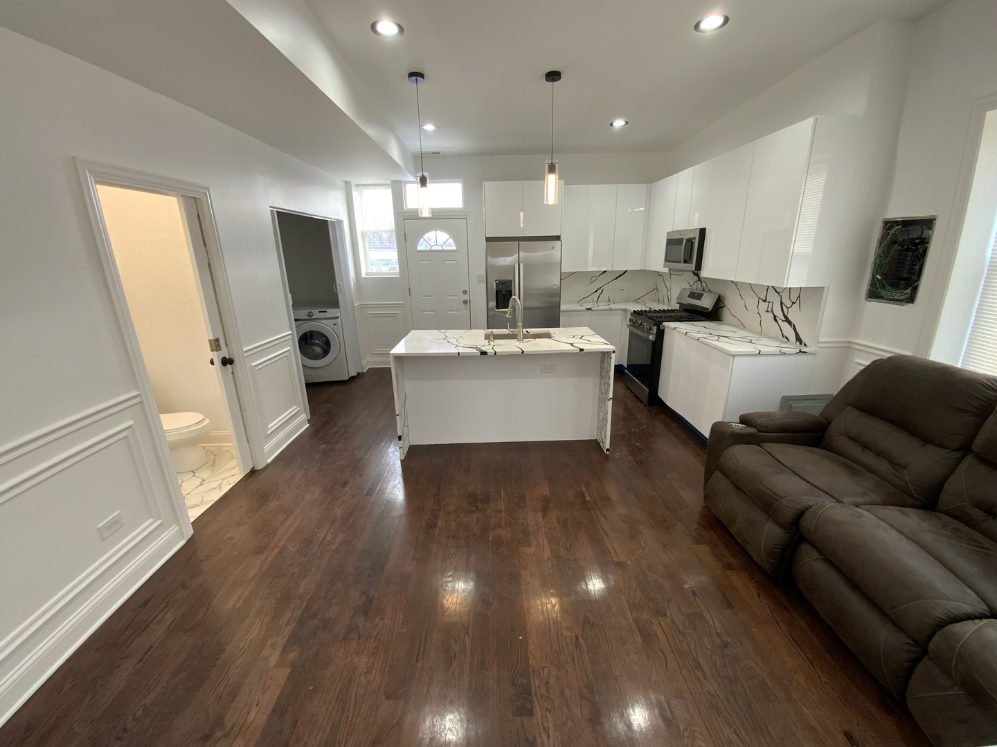 419 East 75th Street, Unit 3 Chicago, IL 60619 - Photo 4 of 11 a living room with stainless steel appliances furniture wooden floor and a kitchen view