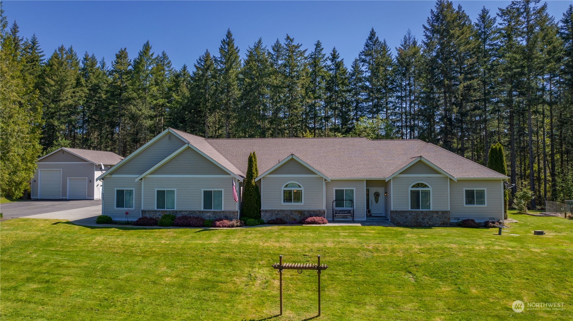 6605 Stringtown Road East Eatonville, WA 98328 - Photo 1 of 40 a front view of a house with a garden and trees