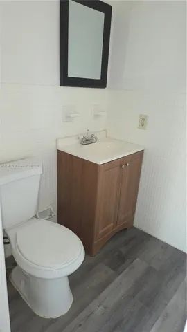a bathroom with a toilet a sink and mirror