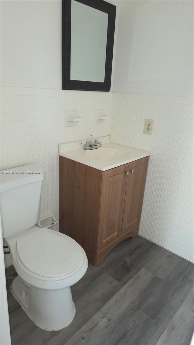 502-504 Phippen Waiters Road, Unit 3 Dania Beach, FL 33004 - Photo 3 of 17 a bathroom with a toilet a sink and mirror