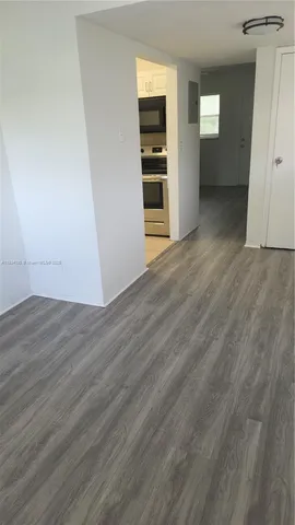 an empty room with wooden floor & closet and windows