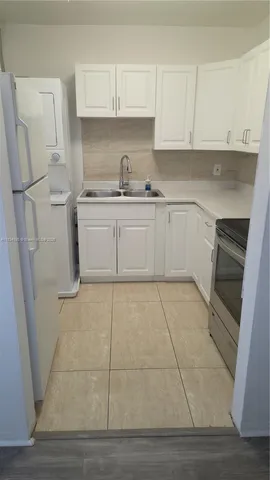 a kitchen with white cabinets and white appliances