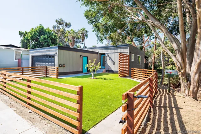 a view of a house with swimming pool and wooden fence