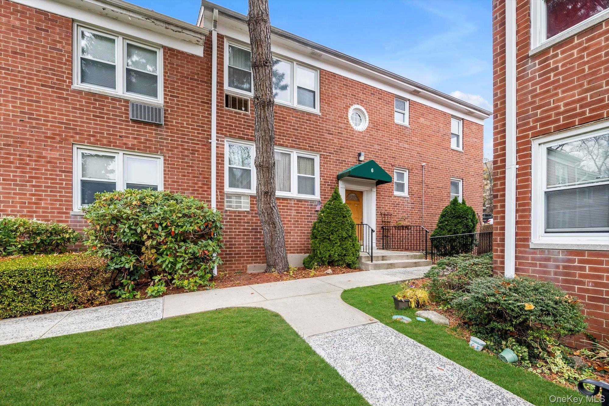 643 Pelham Road, Unit 6D New Rochelle, NY 10805 - Photo 11 of 12 View of front facade with brick siding and a front lawn
