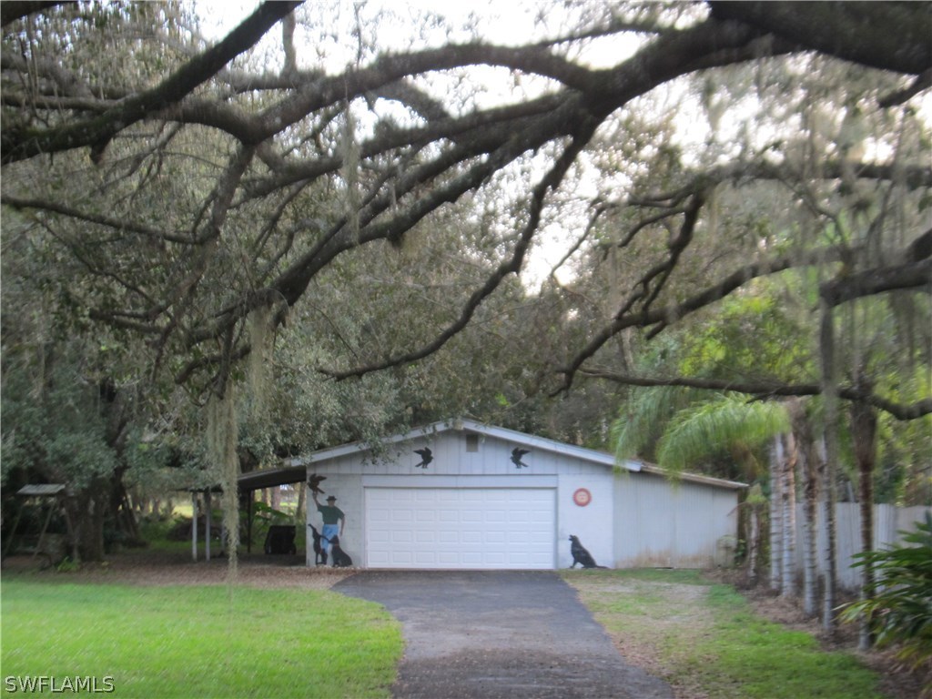 15850 Old Olga Road Alva, FL 33920 - Photo 3 of 11 a front view of a house with a yard and a garage