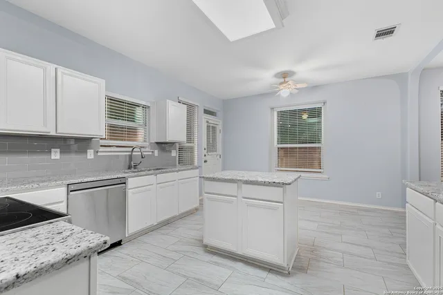 a kitchen with a stove sink and cabinets