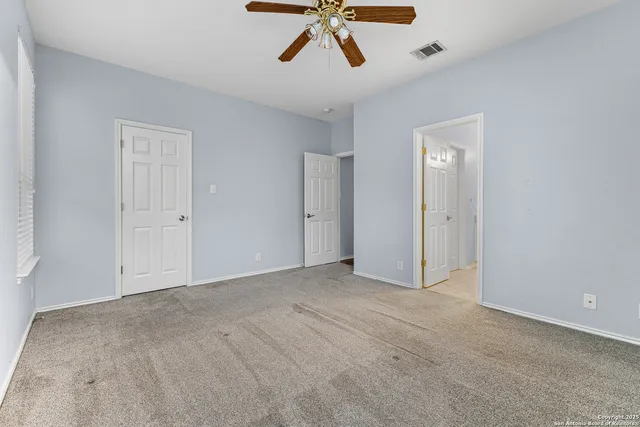 a view of empty room with ceiling fan