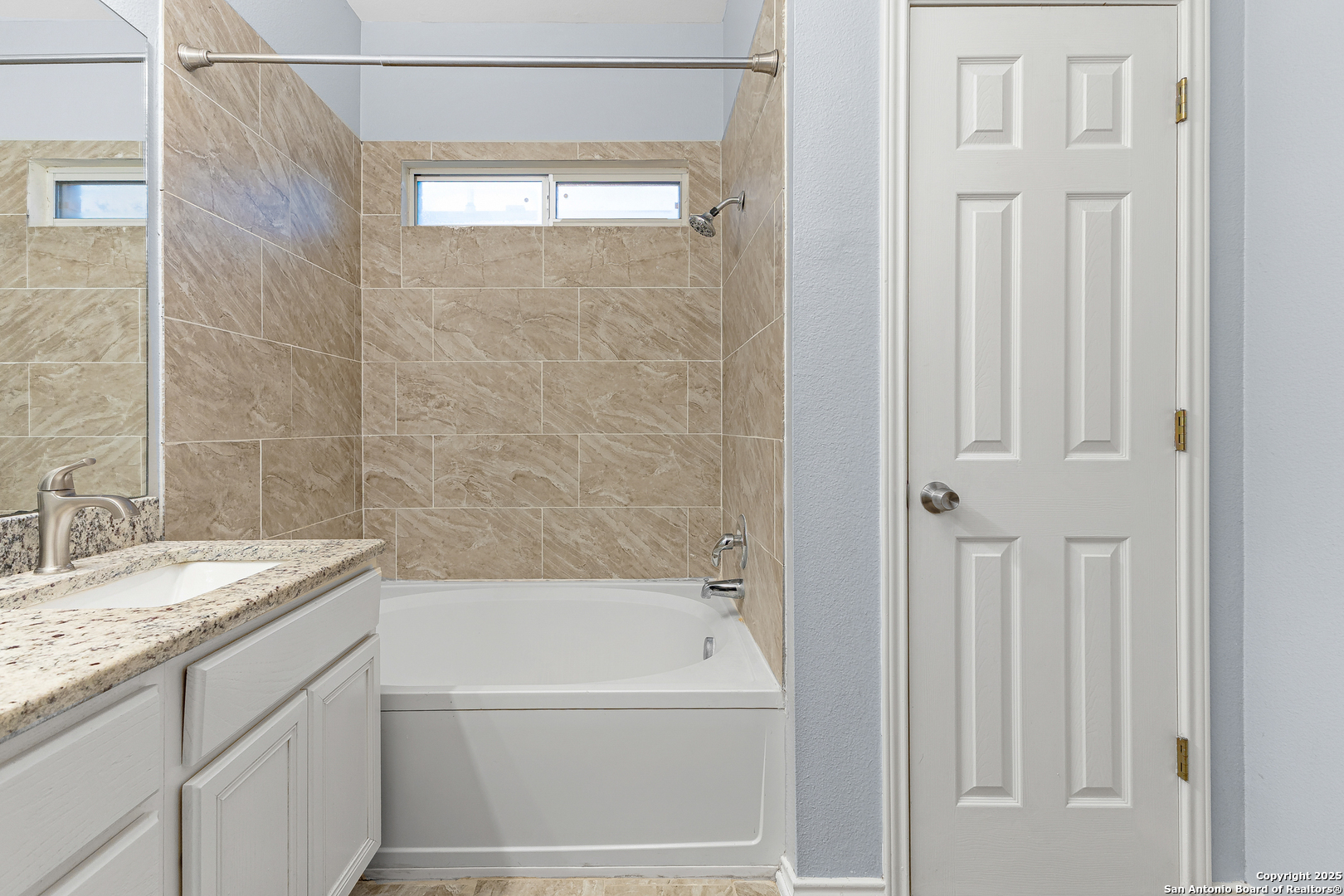 8522 Sonora Pass Helotes, TX 78023 - Photo 23 of 27 a bathroom with a granite countertop bathtub shower sink and vanity