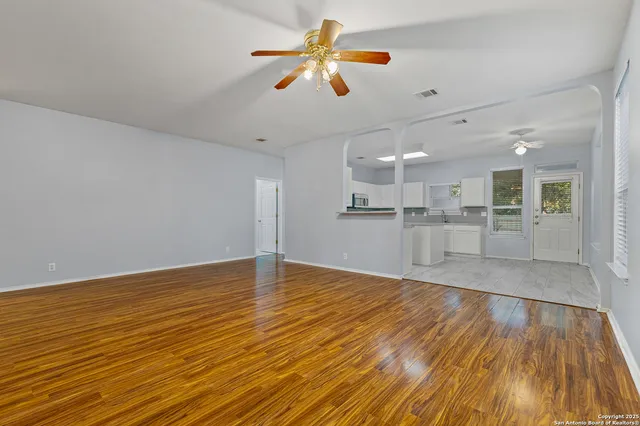 a view of a kitchen with wooden floor and a sink