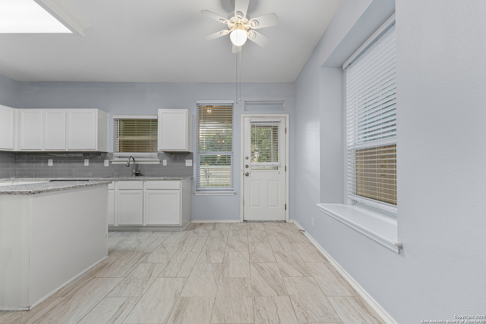 8522 Sonora Pass Helotes, TX 78023 - Photo 9 of 27 a large white kitchen with cabinets a sink and dishwasher