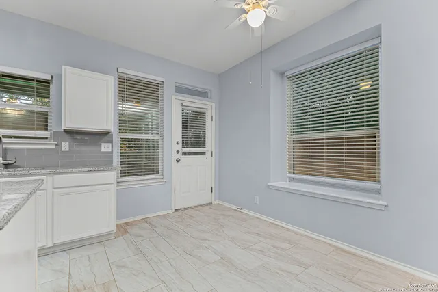 a view of an empty room with a sink and a window