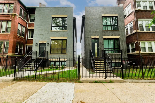 a view of a brick house in front of a yard