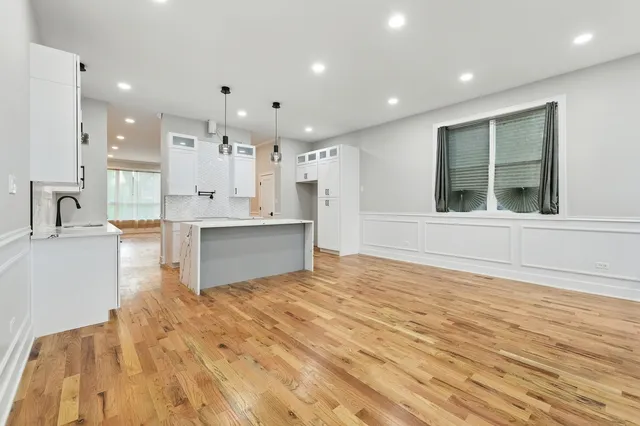 a view of kitchen with kitchen island wooden cabinets and refrigerator