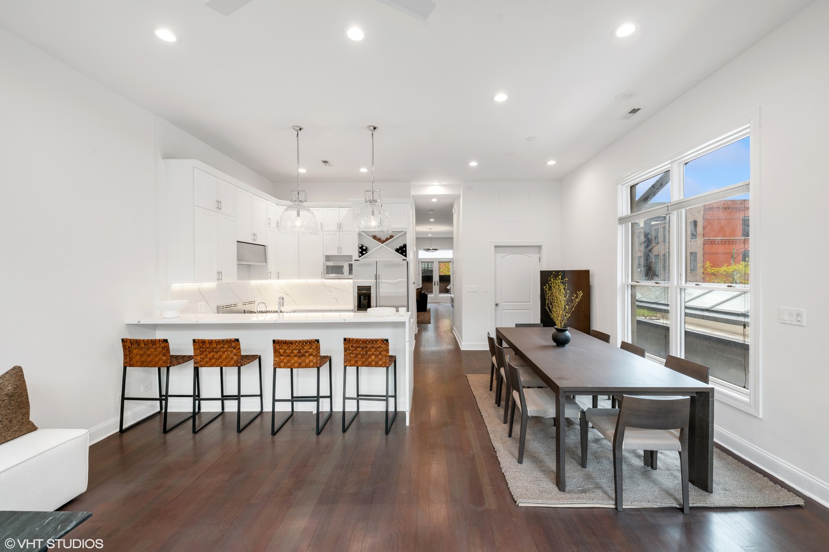 215 North Green Street, Unit 2 Chicago, IL 60607 - Photo 5 of 11 a dining room with stainless steel appliances kitchen island granite countertop a dining table chairs and a refrigerator