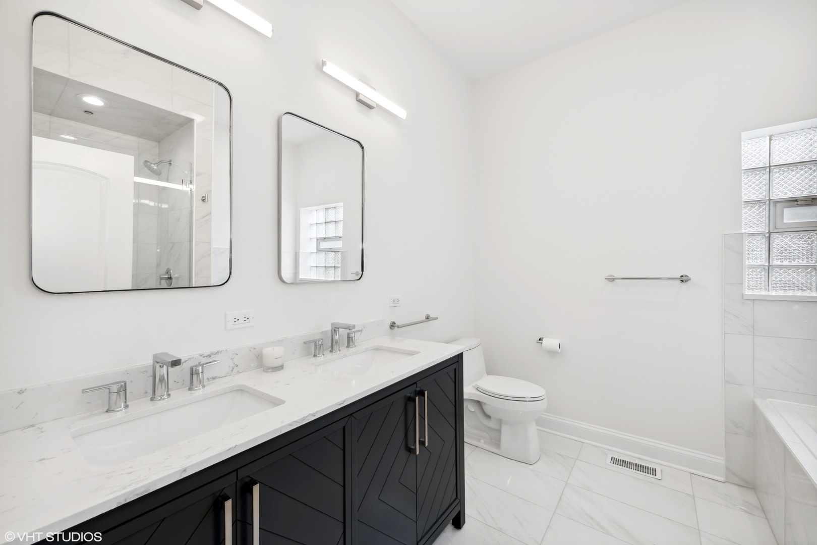215 North Green Street, Unit 2 Chicago, IL 60607 - Photo 8 of 11 a bathroom with a double vanity sink toilet and mirror