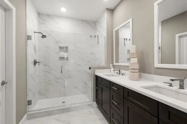 a bathroom with a double vanity sink mirror and shower