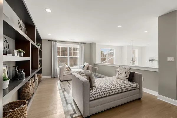 a living room with furniture a flat screen tv and a large window