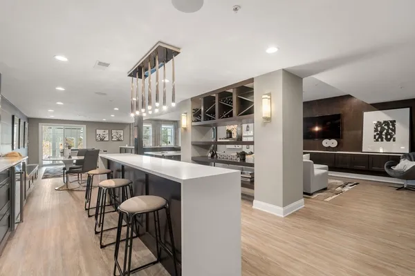 a kitchen with stainless steel appliances a dining table chairs stove and refrigerator