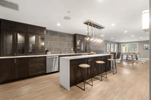 a kitchen with a sink a counter space appliances and cabinets