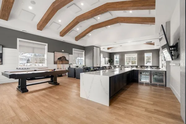 a large living room with stainless steel appliances kitchen island granite countertop a large counter top and furniture