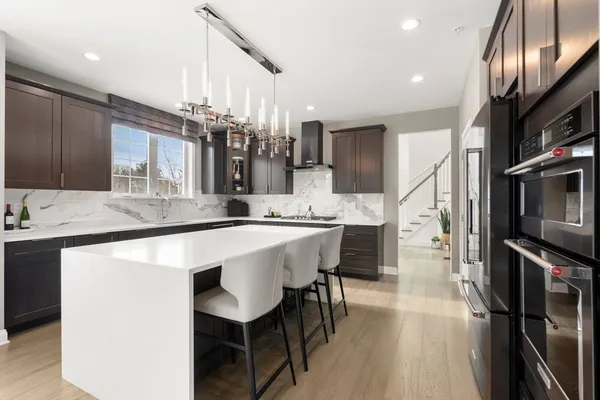 a kitchen with stainless steel appliances kitchen island granite countertop a sink refrigerator and cabinets