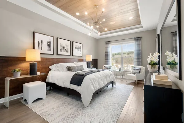 a spacious bedroom with a bed and wooden floor