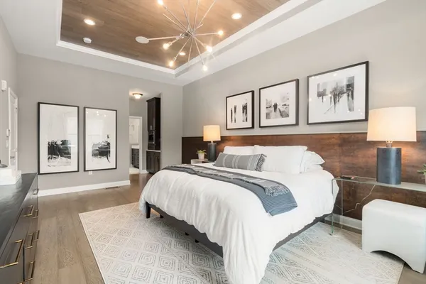 a spacious bedroom with a large bed and a chandelier